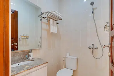 a bathroom with a toilet and a sink and a shower at Stylish 3BR Villa Sandalwood near Beach in Seminyak