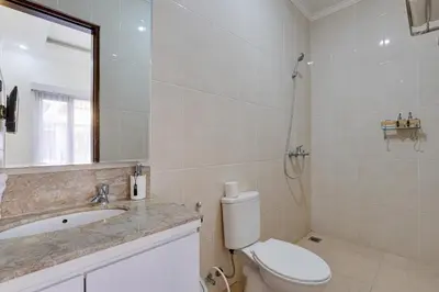 a bathroom with a toilet and a sink and a shower at Stylish 3BR Villa Sandalwood near Beach in Seminyak