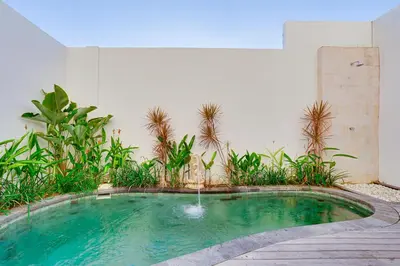 a small pool with a fountain in the middle at Stylish 3BR Villa Sandalwood near Beach in Seminyak