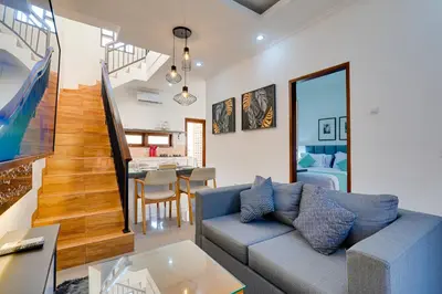a living room with a couch and a dining room at Stylish 3BR Villa Sandalwood near Beach in Seminyak