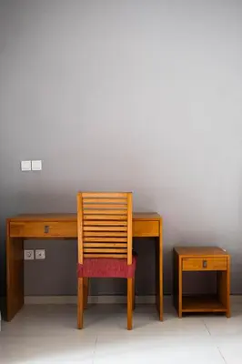 a wooden desk with a chair next to a wall at Bali Bliss Residence in Seminyak