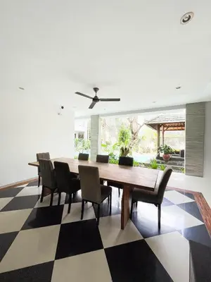 a dining room with a table and chairs on a checkered floor at Bali Bliss Residence in Seminyak