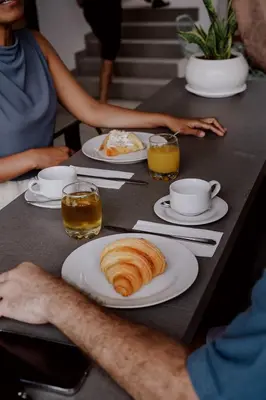 a table with plates of croissants and cups and drinks at Jiva Flow Kerobokan in Kerobokan