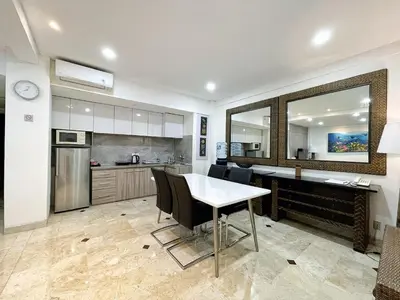 a kitchen with a table and chairs in a room at Jayakarta 6508 Legian Beach Side 2 BR Apartment in Seminyak
