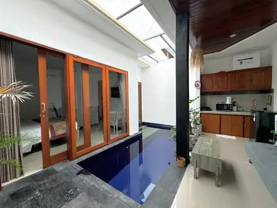 a room with a swimming pool in the middle of a house at CWB Villa in Kerobokan