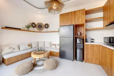 a kitchen with a stainless steel refrigerator and a table at Summer Cinta Seminyak in Seminyak