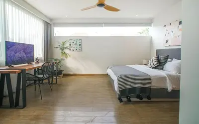 a bedroom with a bed and a desk and a ceiling fan at Desa Berawa Beach Villa No13 in Canggu