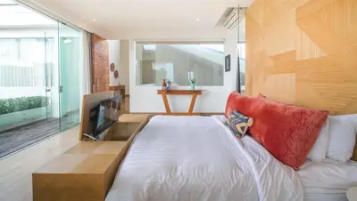a bedroom with a large white bed with red pillows at Desa Berawa Beach Villa No13 in Canggu
