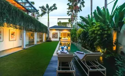 a backyard with two chairs and a pool at Desa Berawa Beach Villa No13 in Canggu