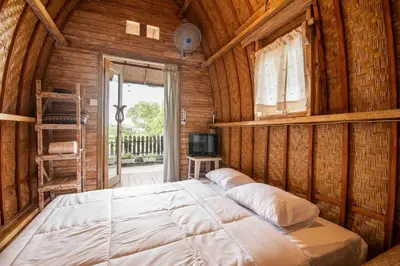 a bedroom with a large bed in a wooden room at Little Farm House Kerobokan near Seminyak in Kerobokan