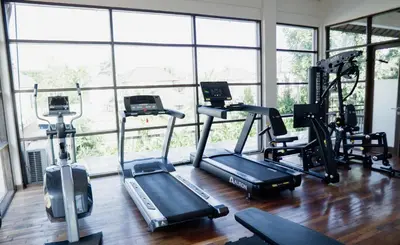 a gym with several treadmills and elliptical machines at Esco Luxe Jimbaran in Jimbaran