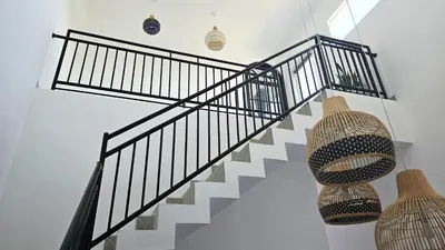 a staircase with black and white railings and vases at MauLagi Bali Getaway in Jimbaran