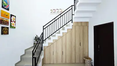 a staircase in a house with white walls at MauLagi Bali Getaway in Jimbaran