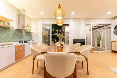a kitchen and dining room with a wooden table and chairs at Villa Palma Blanca Canggu by Nagisa Bali in Canggu