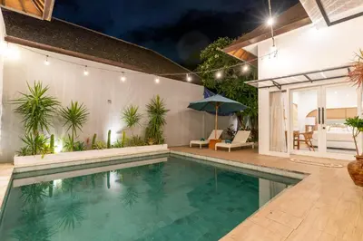 a swimming pool in front of a house at Villa Palma Blanca Canggu by Nagisa Bali in Canggu