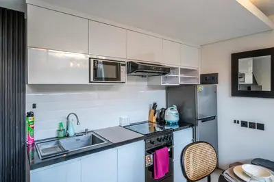 a small kitchen with a sink and a refrigerator at Villa Lotus by Unicorn Villas Bali in Kerobokan