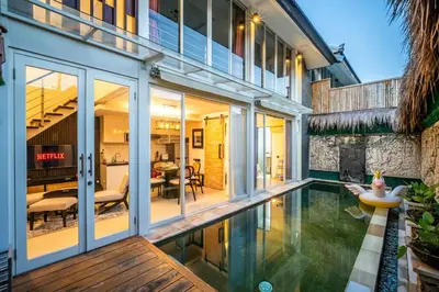a house with a swimming pool next to a building at Villa Lotus by Unicorn Villas Bali in Kerobokan