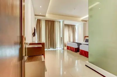 a hotel room with a bedroom with a bed at Dancenter Premium Legian Hotel in Balian