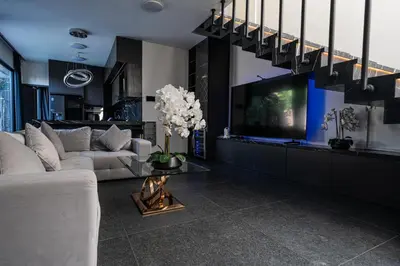 a living room with a white couch and a tv at Villa Maya in Kerobokan