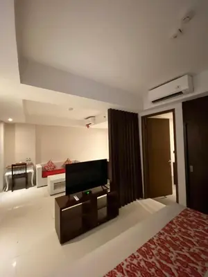 a bedroom with a bed and a tv in a room at Signature Seminyak in Seminyak