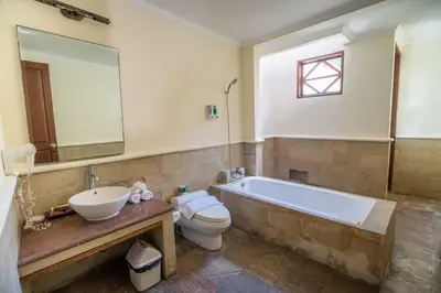 a bathroom with a tub and a toilet and a sink at Classic Pool villa with kitchen in Seminyak