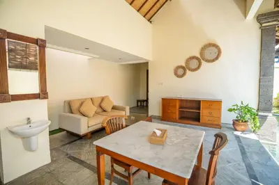 a living room with a table and a couch at Classic Pool villa with kitchen in Seminyak