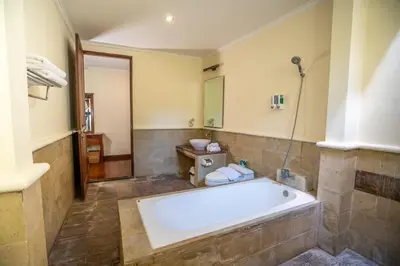 a large bathroom with a tub and a toilet at Classic Pool villa with kitchen in Seminyak