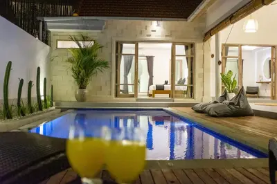 a swimming pool in a house with drinks on a table at Harmony Villa Two Bedroom in Canggu