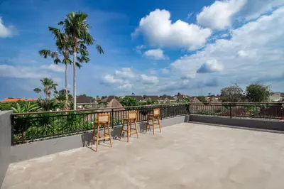 a balcony with chairs and a view of the city at D'House Seminyak in Seminyak
