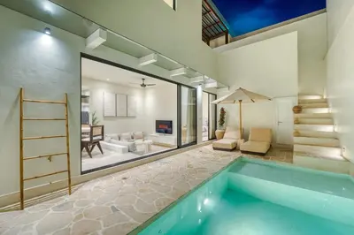 a house with a swimming pool and a living room at Villa Madame 3BR Villa Private Pool in Berawa in Canggu