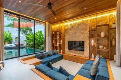 a living room with blue couches and a fireplace at Gelareh Villa Berawa in Canggu