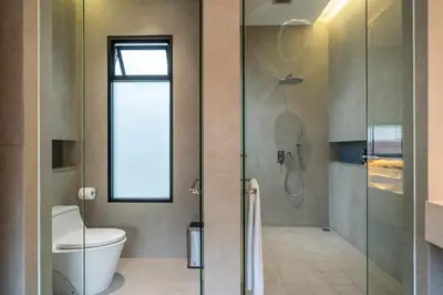 a bathroom with a toilet and a glass shower at Gelareh Villa Berawa in Canggu