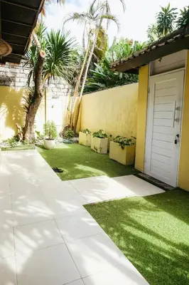 a garden with a lawn and a garage at Villa Frankie in Central Legian in Legian