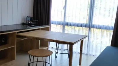 a kitchen with a wooden table and two stools at Esco Luxe Benoa in Nusa Dua