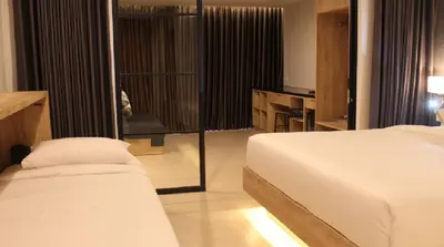 a bedroom with a bed and a sliding glass door at Esco Luxe Benoa in Nusa Dua