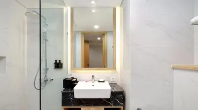 a bathroom with a white sink and a mirror at Esco Luxe Benoa in Nusa Dua