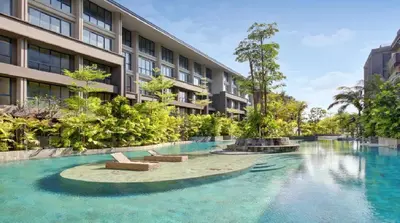 a swimming pool in front of a building at Esco Luxe Benoa in Nusa Dua