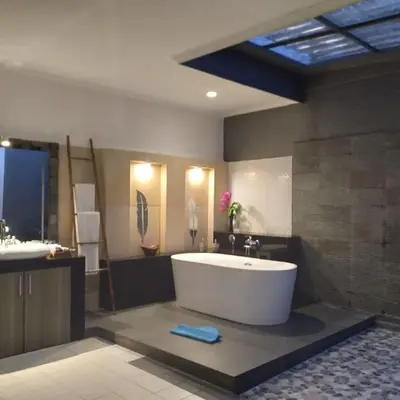 a large bathroom with a tub and a sink at Sandy Shores Bali in Seminyak