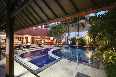 an outdoor swimming pool with a resort building at Sandy Shores Bali in Seminyak