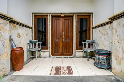 a front door of a house with two chairs at Gracia Apartment Seminyak Managed by Manara in Seminyak