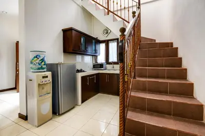 a kitchen with a staircase in a house at Gracia Apartment Seminyak Managed by Manara in Seminyak