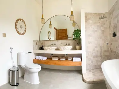 a bathroom with a sink and a toilet and a mirror at Cozy and Chic Villa with Private Pool at Balangan in Jimbaran