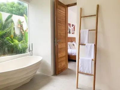 a bathroom with a bath tub and a bedroom at Cozy and Chic Villa with Private Pool at Balangan in Jimbaran