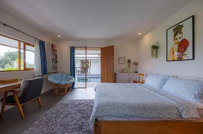 a bedroom with a bed and a table and a desk at Villa Rice - Amazing Rice-Field VIEW 3BR Villa 9px Next To Canggu in Kerobokan