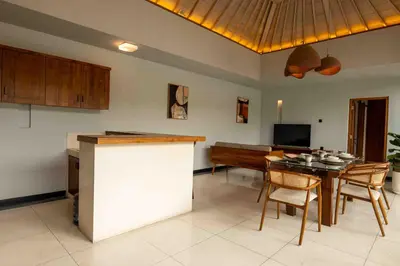 a kitchen and dining room with a table and a piano at Tuluscolivingseminyakvilla1 in Seminyak