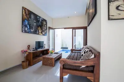 a living room with a couch and a television at The Lavana Villa De Kerobokan in Seminyak