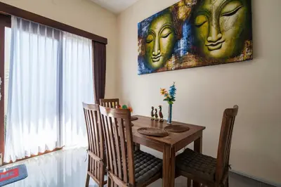 a dining room table with two faces on the wall at The Lavana Villa De Kerobokan in Seminyak