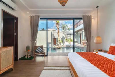 a bedroom with a bed and a view of a pool at Villa Bella Wilson 4 in Seminyak