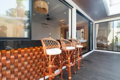 a row of chairs sitting at a bar on a balcony at Villa Bella Wilson 4 in Seminyak
