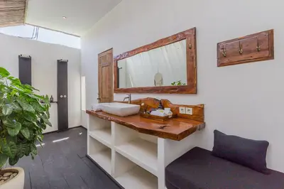 a bathroom with a wooden sink and a mirror at Villa Ubuntu 3BR Pool Ricefield Family&Friends group near Canggu in Kerobokan